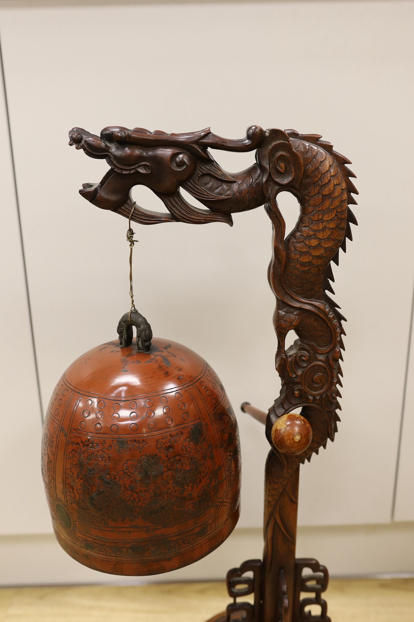 A Chinese carved hongmu 'dragon' stand with Japanese bell, 73cm tall